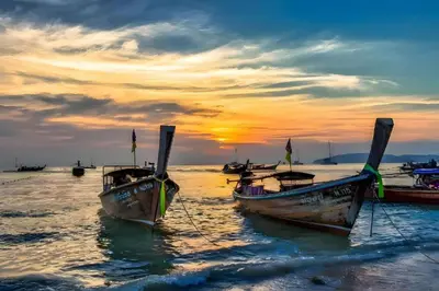 a group of boats sitting in the water at sunset at XX GO Inn Krabi Aonang Beach - โกอินน์ อ่าวนาง in Ban Khlong Haeng
