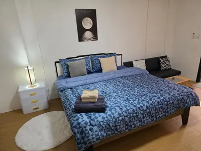 a bedroom with a bed with a blue comforter at Monkey Apartment 3 in Patong Beach