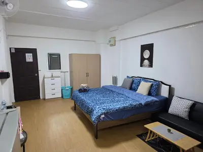 a bedroom with a blue bed and a couch at Monkey Apartment 3 in Patong Beach
