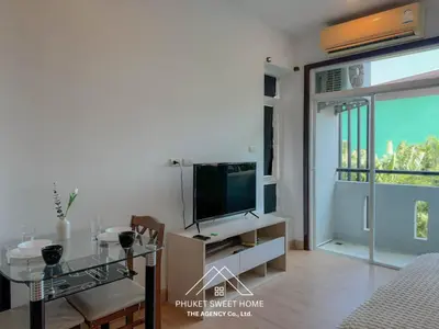 a living room with a television and a glass table at THe bell chalong phuket 19 in Ban Klang