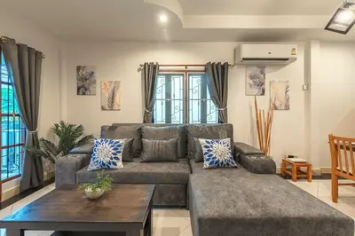 a living room with a couch and a table at Coastline Pearl Holiday Home, Bangtao Beach in Ban Thalat Choeng Thale
