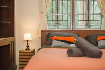 a bedroom with a bed with a large window at Areca Holiday Home 1, Bangtao Beach in Ban Thalat Choeng Thale
