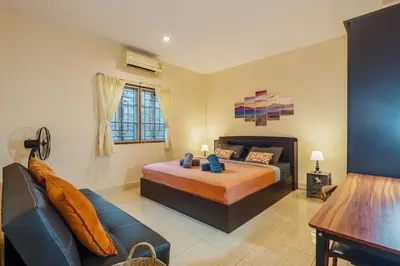 a bedroom with a bed and a couch at Areca Holiday Home 1, Bangtao Beach in Ban Thalat Choeng Thale