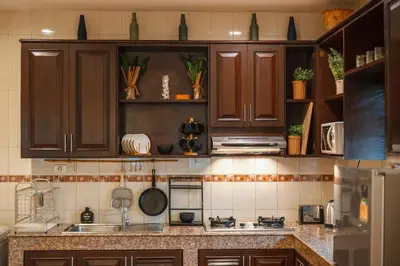 a kitchen with wooden cabinets and a counter top at Areca Holiday Home 1, Bangtao Beach in Ban Thalat Choeng Thale