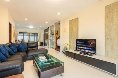 a living room with a leather couch and a flat screen tv at First Ao Nang Private Pool Villa in Ao Nang Beach