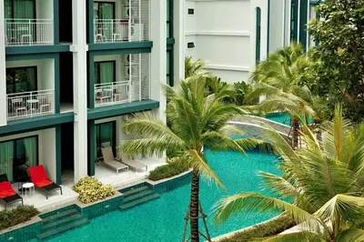 an apartment building with a swimming pool and palm trees at The Title Halo1 350 m to NaiYang Brand-New 1BR in Nai Yang Beach