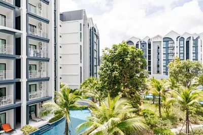 an apartment building with a swimming pool and palm trees at The Title Halo1 350 m to NaiYang Brand-New 1BR in Nai Yang Beach