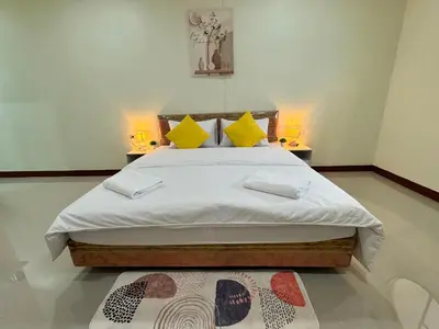 a bedroom with a large bed with two lamps at Muttafa House in Nai Yang Beach