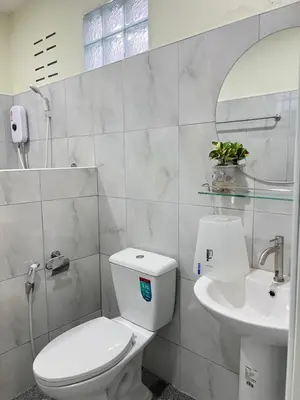 a bathroom with a white toilet and a sink at Muttafa House in Nai Yang Beach