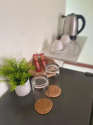 a kitchen counter with two glasses and a potted plant at Muttafa House in Nai Yang Beach