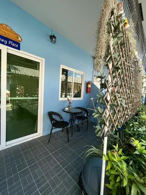 a patio with chairs and a table on a blue wall at Yada House Sunny Place in Ban Bo Han