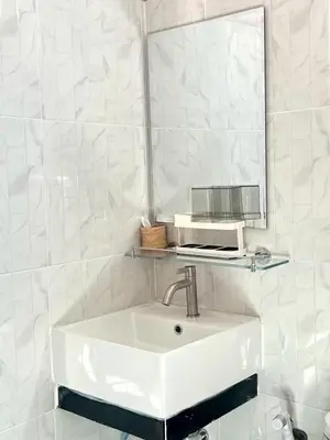 a white bathroom with a sink and a mirror at Yada House Sunny Place in Ban Bo Han