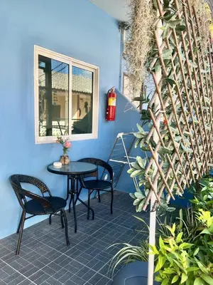 a patio with a table and chairs and a blue wall at Yada House Sunny Place in Ban Bo Han