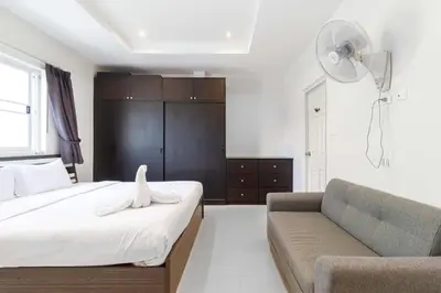 a bedroom with a bed and a couch and a fan at C230 Chill 1BR Sea View, Near Beach & Muay Thai in Rawai Beach