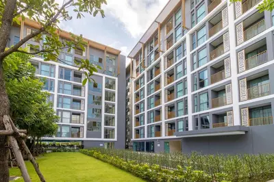 an apartment building with a lawn in front of it at C227 Brand New Condo Near Top Phuket Beach Clubs in Bang Tao Beach