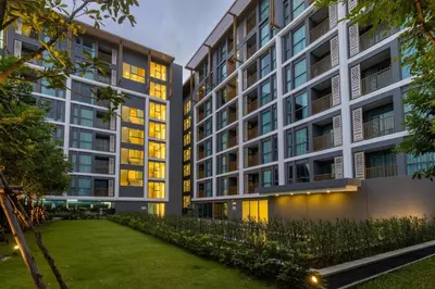 an apartment building with a lawn in front of it at C228 Brand New Condo Near Beach & Prime Location in Bang Tao Beach