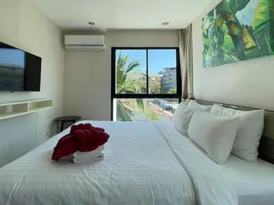 a bedroom with a bed with a red stuffed animal on it at The Title Rawai Aparthotel by HSS in Rawai Beach