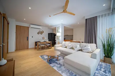 a living room with a white couch and a table at Beachside 1 BR apartment by NLA in Bang Tao Beach