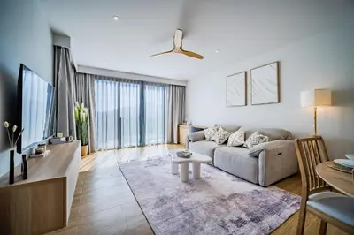 a living room with a couch and a table at Beachside 1 BR apartment by NLA in Bang Tao Beach