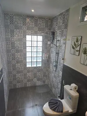 a bathroom with a toilet and a shower at Tropical Hideaway Close to the Beach in Ban Thalat Choeng Thale