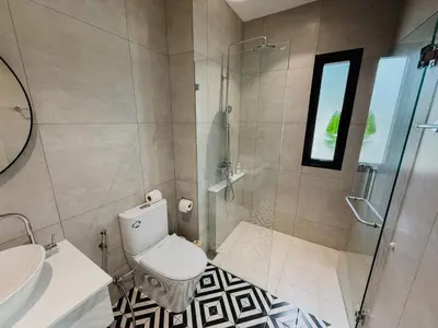 a bathroom with a toilet and a glass shower at FAMILY HOMES - Brand New 2BDRM Poolside Apartment in Phuket