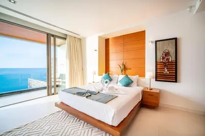 a bedroom with a large bed and a large window at Kamala Beach Front Sea View 6 Bedroom Villa in Kamala Beach