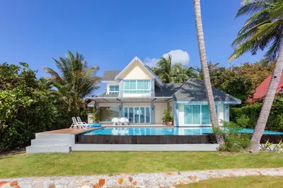 a house with a swimming pool and palm trees at Fisherman Way Beach Villa in Rawai Beach