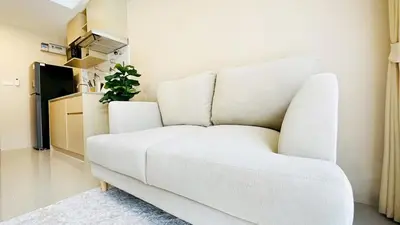 a white couch in a living room with a plant at Cozy condo maikhao Phuket in Ban Mai Salae