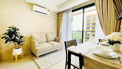 a living room with a table and a couch at Cozy condo maikhao Phuket in Ban Mai Salae