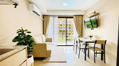 a living room with a couch and a table with chairs at Cozy condo maikhao Phuket in Ban Mai Salae