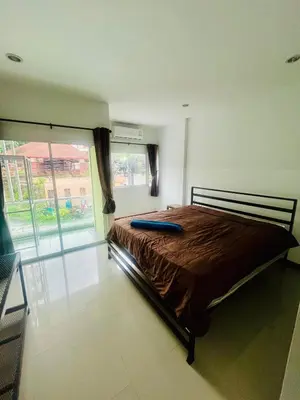 a bed in a room with a large window at Ann & John Guesthouse in Patong Beach