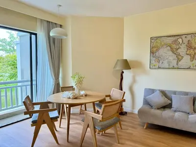 a living room with a table and chairs and a couch at Cozy 1 BR Allamanda Laguna Phuket in Laguna Phuket