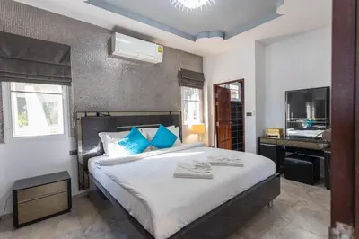 a bedroom with a bed with a desk and a television at Tropical 2BR Villa Sunset & Sea View in Karon Beach