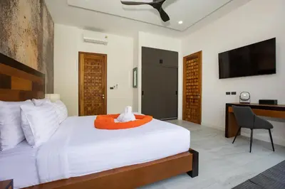 a bedroom with a bed and a desk and a television at Andaman Paradise 2 Luxury 4 Bedrooms Pool Villa in Rawai Beach