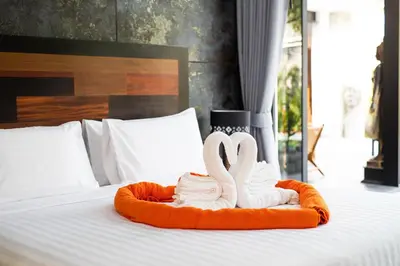 two swans made to look like flamingos sitting on a bed at Andaman Paradise 3 - Luxury 4 Bedrooms Pool Villa in Rawai Beach