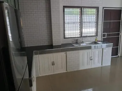 a kitchen with white cabinets and a sink and two windows at Hillside 3 Bedroom Vacation Home with Pool in Kamala Beach