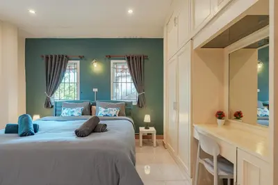 a bedroom with two beds and a desk in it at Areca Holiday Home 7, Bangtao Beach in Ban Thalat Choeng Thale