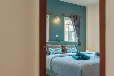 a bedroom with a large bed with a mirror at Areca Holiday Home 7, Bangtao Beach in Ban Thalat Choeng Thale