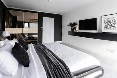 a bedroom with a large white bed and a tv at Patong Tower 2 Bedroom Sea View 8 Floor in Patong Beach