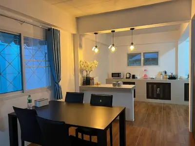 a dining room and kitchen with a table and chairs at Karon Beach Villa in Karon Beach