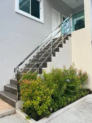 a house with a staircase and some bushes at Karon Beach Villa in Karon Beach