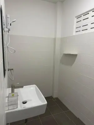 a white bathroom with a sink and a shower at Karon Beach Villa in Karon Beach