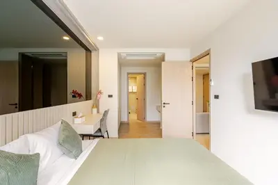 a bedroom with a white bed and a bathroom at The Ozone Condotel Phuket BangTao Beach Spacious 1-BR in Laguna Phuket