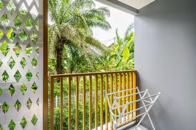 a balcony with a view of a palm tree at The Ozone Condotel Phuket BangTao Beach Spacious 1-BR in Laguna Phuket