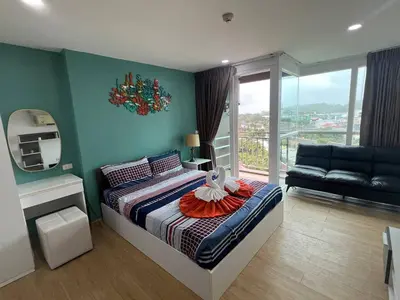 a bedroom with a bed with a mirror and a couch at OZONE Best Studio After Renovation 2025 in Kata Beach