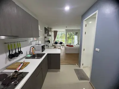 a kitchen with a sink and a living room at OZONE Best Studio After Renovation 2025 in Kata Beach