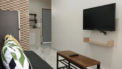 a living room with a couch and a tv on a wall at Best Bliss, Bangtao Beach in Ban Thalat Choeng Thale