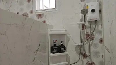 a bathroom with a shower with bottles on the wall at Best Bliss, Bangtao Beach in Ban Thalat Choeng Thale