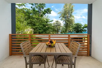 a wooden table with two chairs and a bowl of fruit at Studio Apartment - Nakalay Palm in Kamala Beach