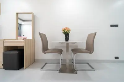a table with two chairs and a vase with flowers at Studio Apartment - Nakalay Palm in Kamala Beach